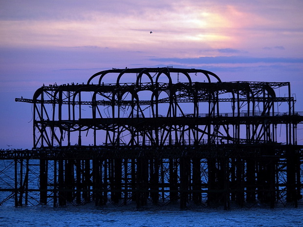 Brighton West Pier sunset - photos of the autumnal sun setting over the doomed Victorian pier, Sussex, England