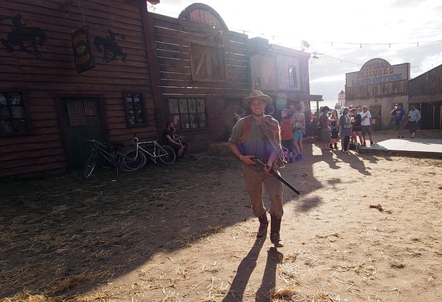 Pistol packin' bucking bronco scenes from Boomtown's Wild West, Boomtown Fair Festival 2015, Winchester, England, UK, August 2015