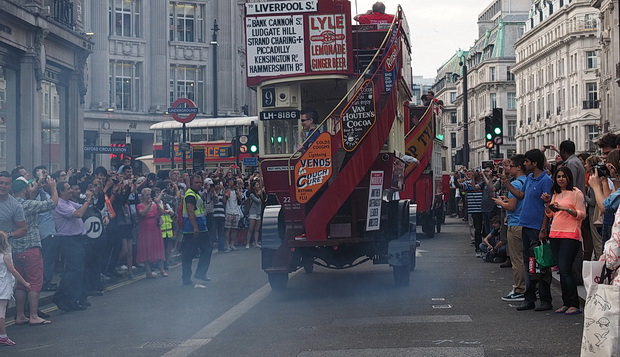 Exhaust fumes hang in the air as the Bus Cavalcade heads off towards Oxford Circus, London