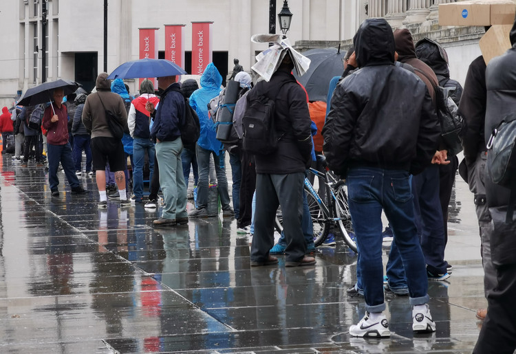 London's shame: long line of hungry homeless people queuing in the rain at Trafalgar Square