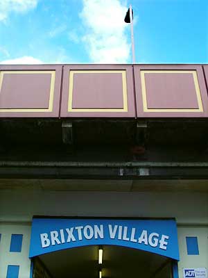 Brixton Village sign and railway station, Atlantic Road, Brixton, Lambeth, London, England SW9