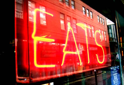 Night view showing 'eats' neon sign, New Piccadilly café, Denman Street, Piccadilly, London