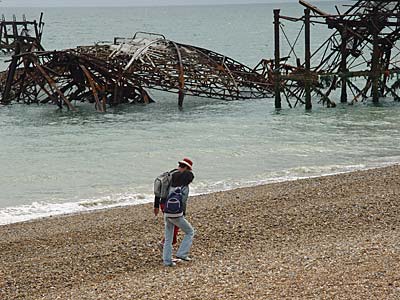 Couple walk past the collapsed concert hall, Brighton West Pier, Brighton, East Sussex