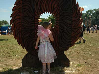 Girl looking through wooden sculpture, Craft Field, Glastonbury Festival, Pilton, Somerset, England June 2005