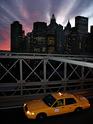 Yellow cab and sunset on Brooklyn Bridge, Manhattan, New York, USA