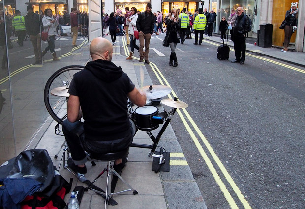 Puncture Kit busker plays on a drum kit made from a bicycle in central London