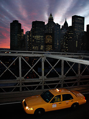 Yellow cab and sunset on Brooklyn Bridge, Manhattan, New York, USA