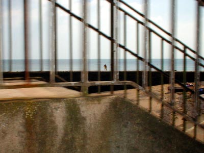Solitary bather and railings, Dawlish beach, Devon