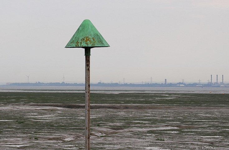 Swimmers and stranded boats on a sea of mud in the shadow of the oil refineries: Leigh on Sea in the summer 