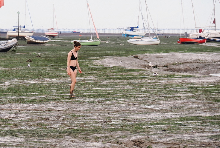 Swimmers and stranded boats on a sea of mud in the shadow of the oil refineries: Leigh on Sea in the summer 