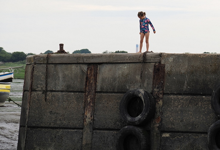 Swimmers and stranded boats on a sea of mud in the shadow of the oil refineries: Leigh on Sea in the summer 